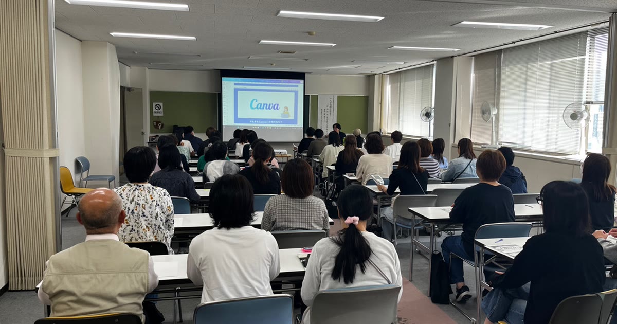 亀岡市総合福祉センターの講習室。スクリーンにCanvaの説明を映し、参加者の皆さまが前を向いて聞いている様子
